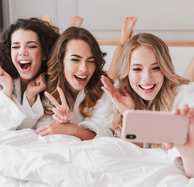 Three women celebrating the results of their microneedling treatment.